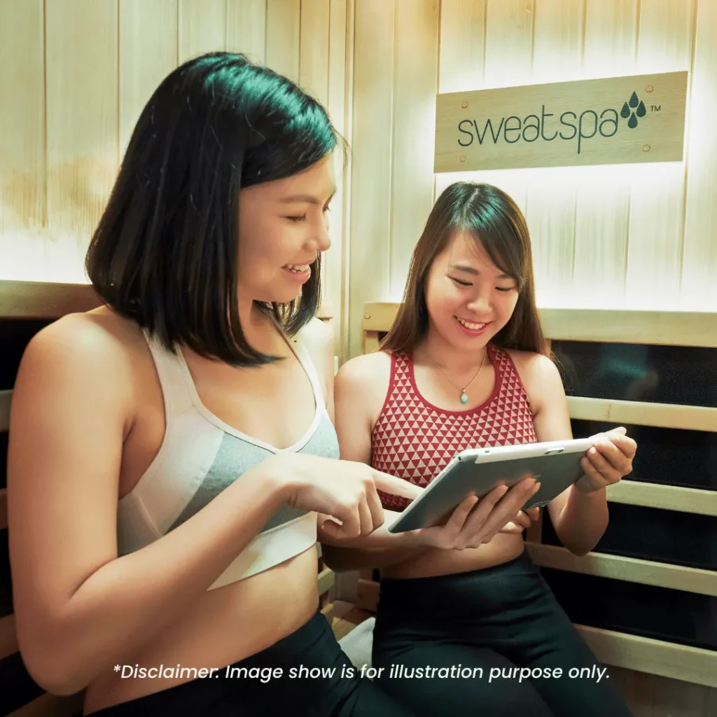 image is showing two people sitting inside the full spectrum infrared sauna, smiling as they enjoying the session. At the bottom, there is a disclaimer saying the image is only for marketing/illustration purpose. When clients book for this session, the the two of them will be put in a separate room