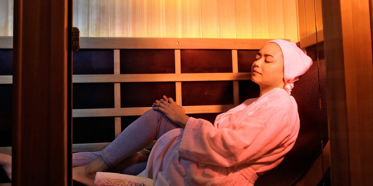 Woman relaxing in infrared sauna during self-care routine