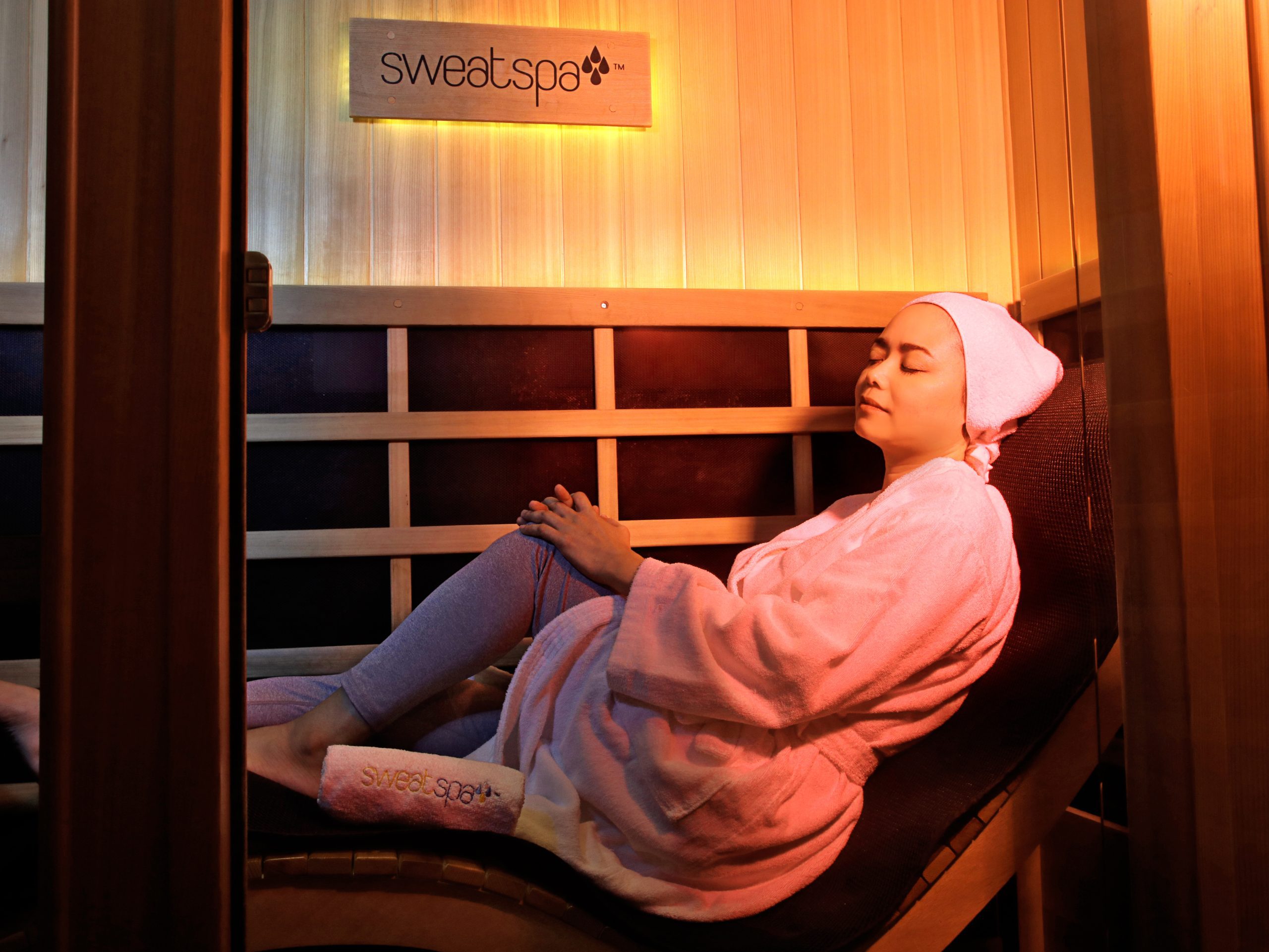 a lady in a cabin doing infrared sauna
