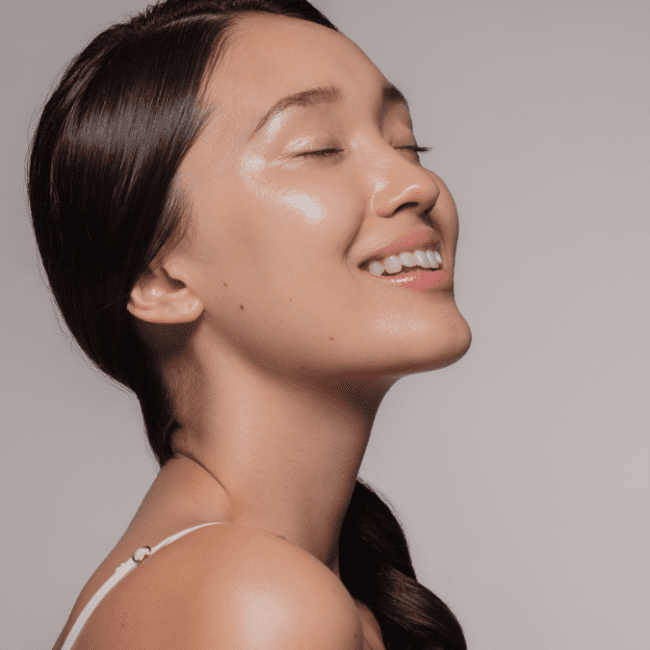 a lady with a braid closing her eyes and smile indicating the feeling of refreshed
